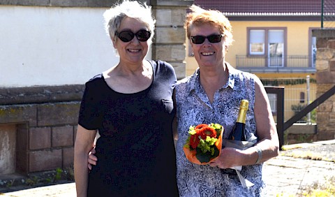 Elke Bechtold mit Gastgeschenk für den Verein ZammeZiehe neben Jutta Grünenwald